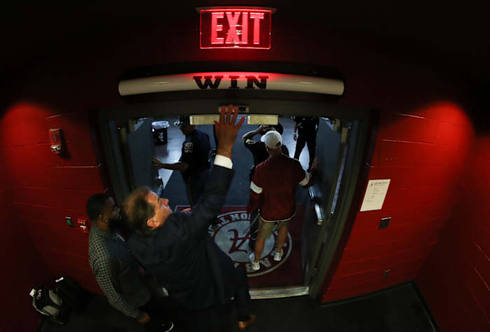 Nick Saban hits the Alabama "Win" bar above the locker room door